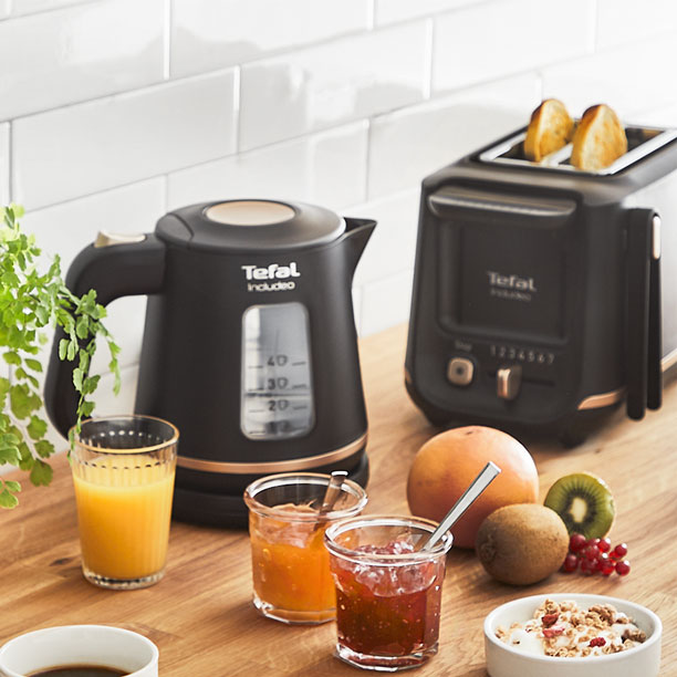 Includeo ergonomic filter coffee maker in use: one hand pours water with the carafe into the large water tank